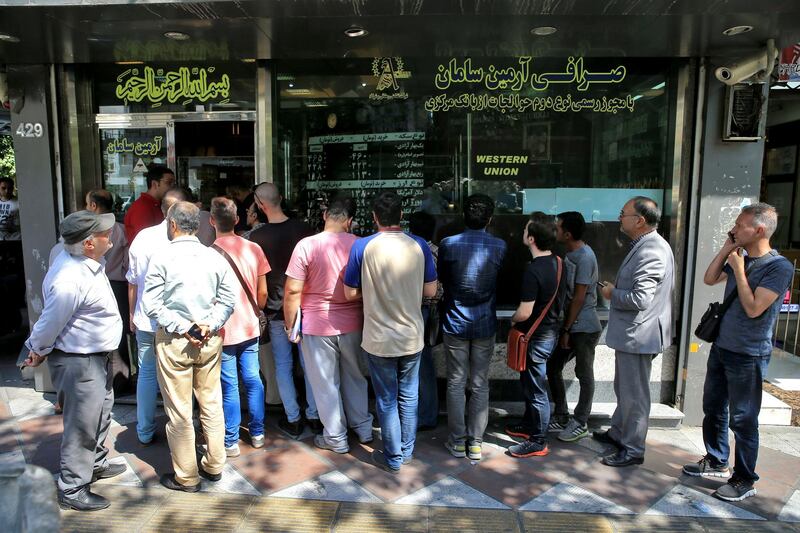 People line up in front of a currency exchange shop to buy U.S. dollars and euros, in downtown Tehran, Iran, Wednesday, Sept. 5, 2018. The Iranian rial fell Wednesday to its lowest rate on record and saw worried residents of Tehran line up outside of beleaguered moneychangers, part of a staggering 140-percent drop in the currency's value since America pulled out of the nuclear deal only four months ago. (AP Photo/Ebrahim Noroozi)