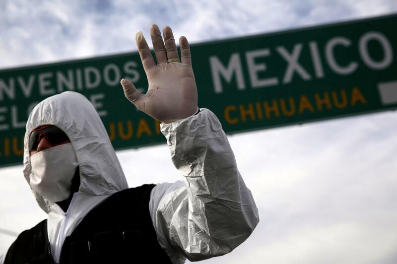 A member of traffic police wearing a protective suit gestures during the coronavirus disease (COVID-19) outbreak at the Mexico and United States border, in Ciudad Juarez, Mexico. REUTERS