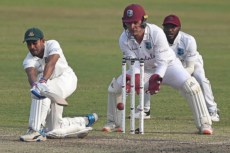 Bangladesh's Mehidy Hasan Miraz  plays a shot as West Indies' wicketkeeper Joshua Da Silva and teammate Jermaine Blackwood look on. AFP