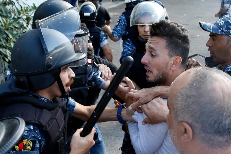 Lebanese riot policemen arrest a Hezbollah supporter during a fight at a protest in Beirut. AP
