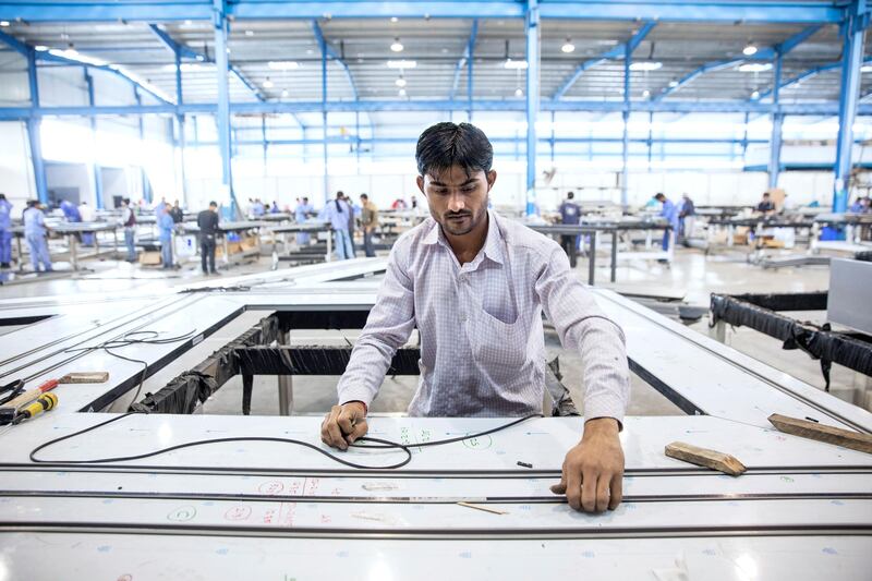 ABU DHABI, UNITED ARAB EMIRATES, Jan. 19, 2015:  
A laborer works, fitting a rubber gasket between the aluminium extrusions and the stainless steel panels on 'stars', which will become cladding pieces for the Louvre Abu Dhabi dome, on Monday, Jan. 19, 2015, at the White Aluminium fabrication plant in Musaffah, Abu Dhabi.  The steel panels are inserted into the stars to give them the reflective quality that is required by Jean Nouvel's concept for the Louvre. A gasket has to be fitted between the stainless steel and the aluminium to prevent the stainless steel and the aluminium from making contact because if they do, then the metals will corrode.(Silvia Razgova / The National)  /  Usage:  undated, RESTRICTED /  Section: NA   /  Reporter:  Nick Leech *** Local Caption ***  SR-150119-LAD0155.jpg SR-150119-LAD0155.jpg