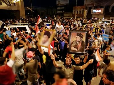 Followers of Shiite cleric Muqtada al-Sadr, seen in the posters, celebrate after the preliminary results of the parliamentary elections are announced, in Tahrir Square, Baghdad, Iraq, early Monday, May 14, 2018. (AP Photo/Hadi Mizban)