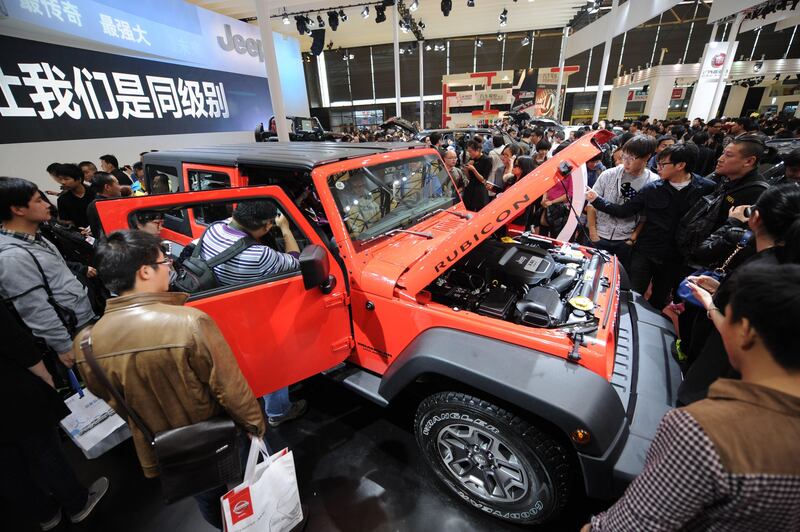 Visitors look at a Jeep Wrangler on the opening day of the Shanghai auto show on April 21, 2013. Chinese buyers swarmed around hundreds of vehicles at the Shanghai auto show at its opening highlighting the importance of the world's largest car market to manufacturers.  AFP PHOTO/Peter PARKS
 *** Local Caption ***  958067-01-08.jpg