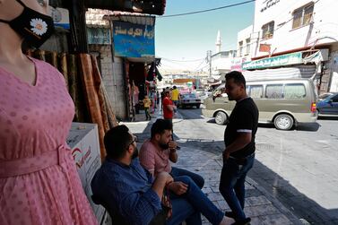 Young Jordanians sit on the sidewalk in the center of Karak, a neglected provincial town about two hours by car from the Jordanian capital of Amman, June 22, 2021.  Hope is hard to come by in Jordan's rural areas and provincial towns that are home to the kingdom's original Bedouin tribes.  Unemployment in the Karak region has reached 40%.  (AP Photo / Raad Adayleh)