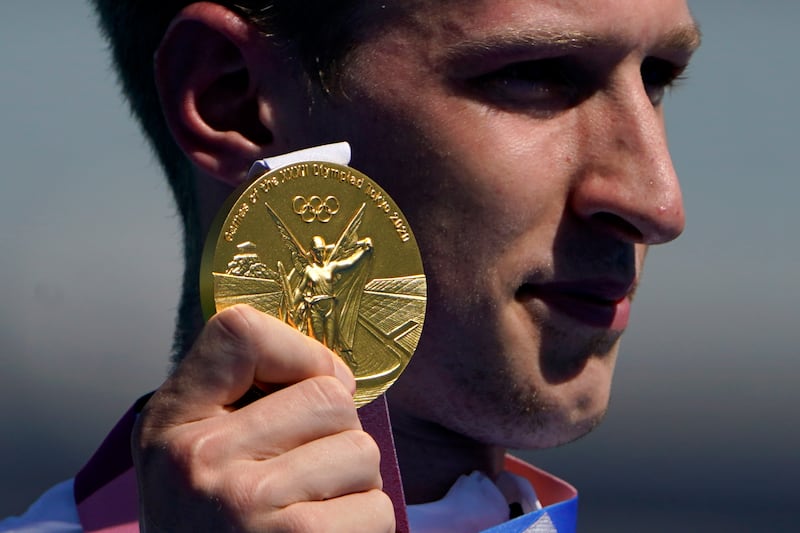 Florian Wellbrock, of Germany, holds up his gold medal during a victory ceremony for the men's marathon swimming event at the 2020 Summer Olympics.