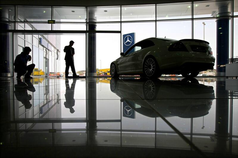 United Arab Emirates - Abu Dhabi - May 07 - 2009 : Workers clean the floor beside a Mercedes-Benz car inside Emirates Motor Company in Mussaffah. ( Jaime Puebla / The National )