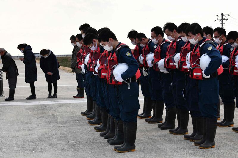 Police in Miyagi Prefecture offer silent prayers for the victims of the earthquake and tsunami that struck Japan in 2011 before searching for evidence of people still missing. AFP