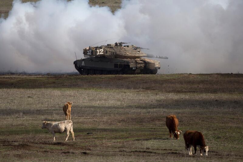 FILE - In this Jan. 11, 2016, file photo, an Israeli Merkava Mark 4 tank drives close to livestock during an exercise in the Israeli-controlled Golan Heights, near the border with Syria. President Donald Trumpâ€™s move to recognize Israeli sovereignty over the Golan Heights turns the tables on decades of U.S. diplomacy and international law and threatens to further inflame regional tensions. (AP Photo/Ariel Schalit, File)