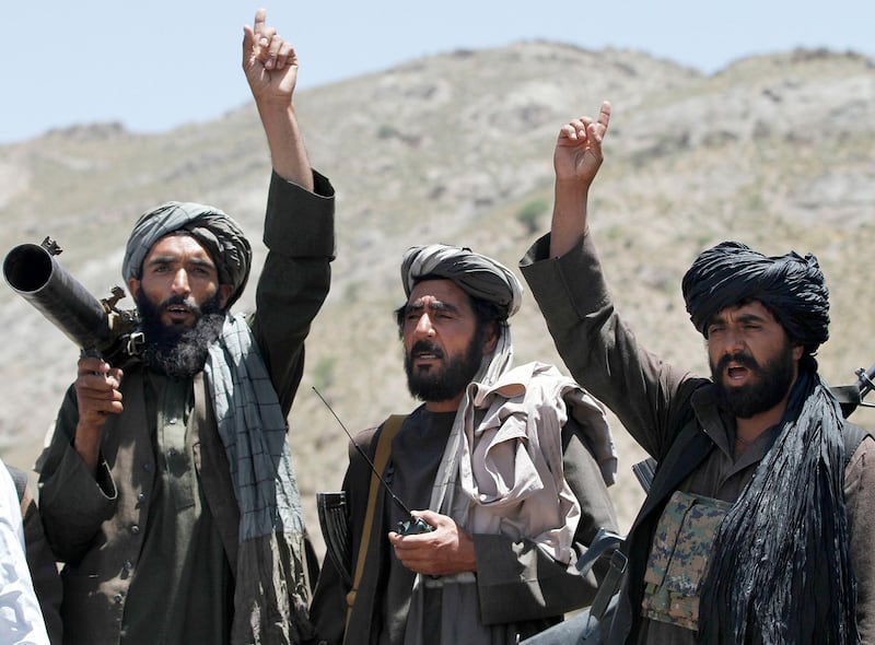 FILE - In this May 27, 2016 file photo, Taliban fighters react to a speech by their senior leader in the Shindand district of Herat province, Afghanistan. With U.S. support, the Afghan government has made a surprising new peace offer to the Taliban, only to immediately run into a wall. The insurgents show no sign of shifting from their demand that talks for a conflict-ending compromise take place with Washington, not Kabul.  (AP Photos/Allauddin Khan, File)