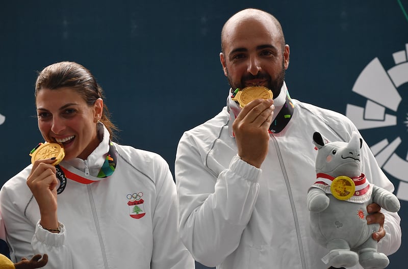 Gold medallists Lebanon's Ray Bassil (L) and Alain Moussa (R) pose for photographers during the victory ceremony for the trap mixed team shooting event at the 2018 Asian Games in Palembang on August 21, 2018. (Photo by ADEK BERRY / AFP)