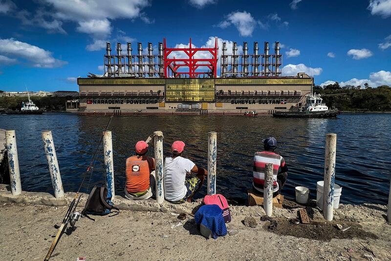 Fishermen watch the electricity-generating vessel Suheyla Sultan arriving in Havana Bay, Cuba. AFP

