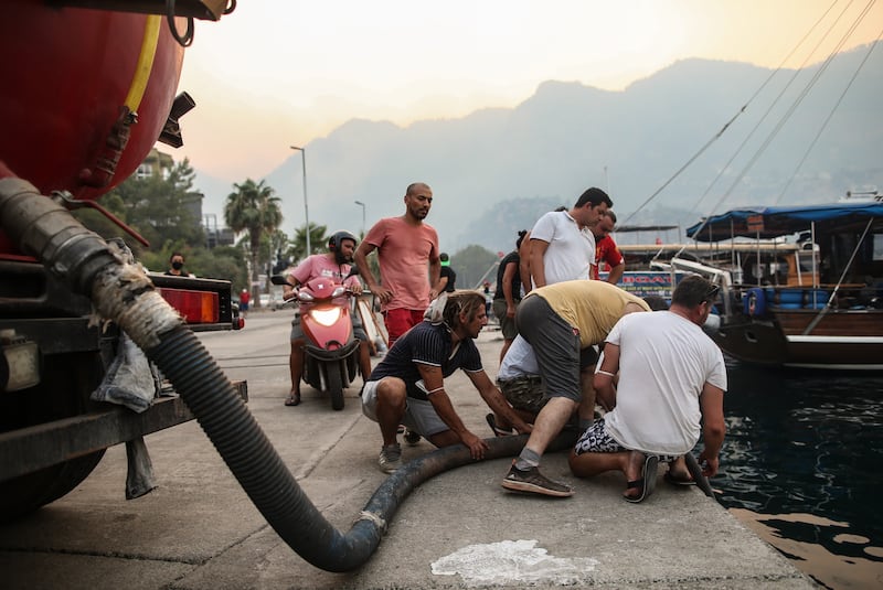 Locals take water from the sea to battle the blaze in Turunc.