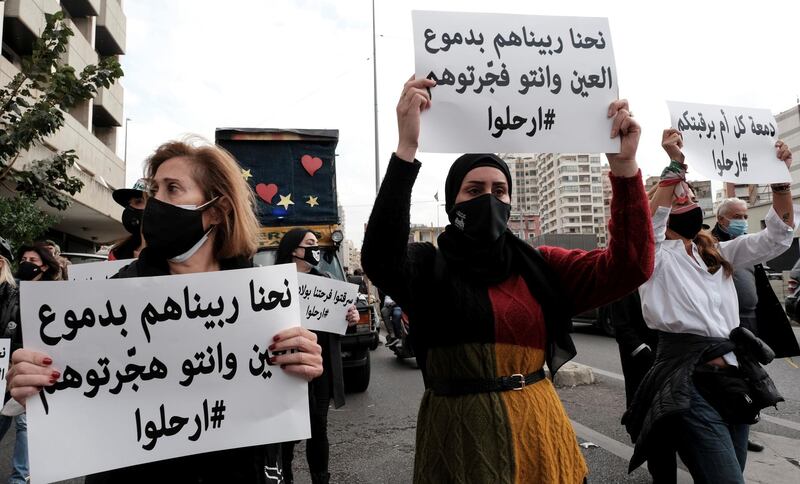 Women carry signs as they take part in a march to protest against the political and economic situation, ahead of Mother's Day in Beirut. The signs read: "We've raised them with our tears, only for you to force them abroad" (L) and "We've raised them with our tears, and you blew them up"(C). Reuters