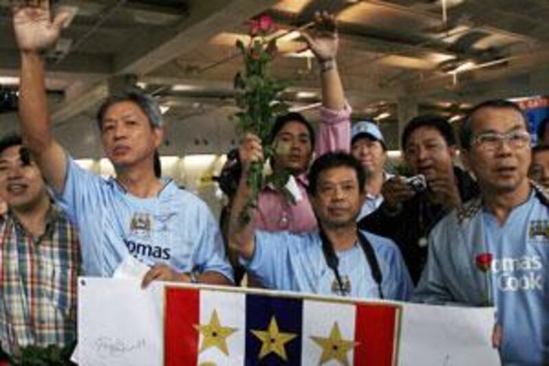 Thai fans of Manchester City club wave the team members on their arrival at the Bangkok airport in November 2007.