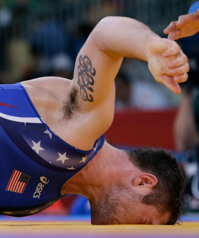 United States' Benjamin Provisor buries his head in the mat as he competes with Cuba's Alexei Bel during the 74-kg Greco-Roman wrestling competition at the 2012 Summer Olympics, Sunday, Aug. 5, 2012, in London. (AP Photo/Paul Sancya)