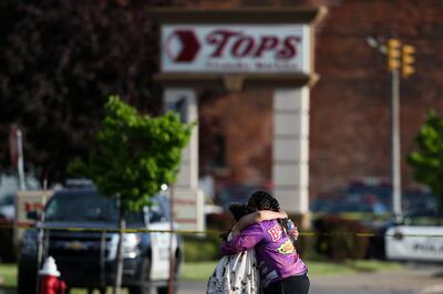 People comfort each other at the scene of the shooting. AP