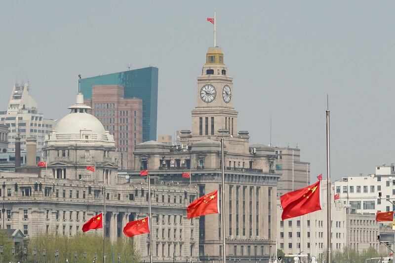 The Chinese flag flies at half mast on buildings to commemorate those who died in the coronavirus outbreak, in Shanghai. AFP