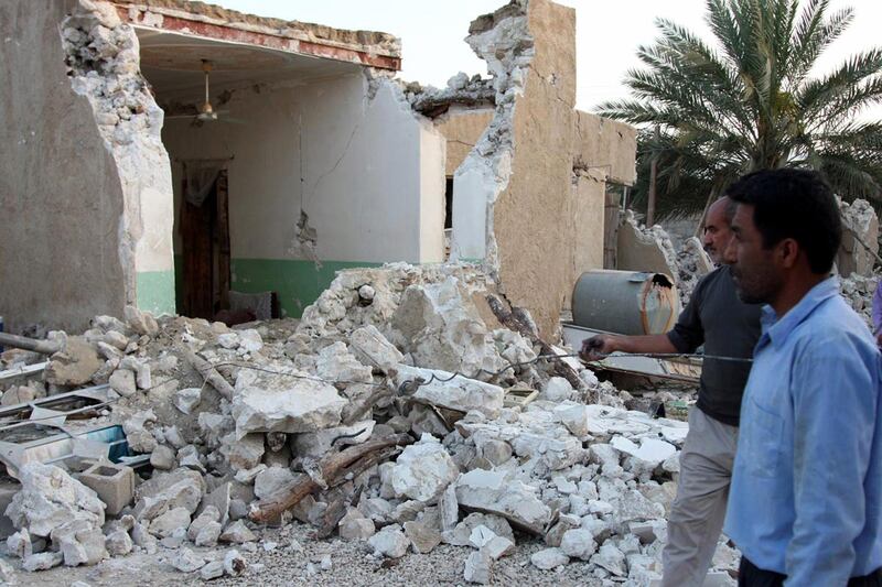 epa03655901 Iranian men stand next to their home after an earthquake in the Shonbeh Twon in Bushehr province in southern Iran, 09 April 2013. The quakes, ranging in magnitude 6.3 on the Richter Scale, shook the Shanbeh town and other communities in Bushehr province in southern Iran on 09 April 2013. At least 37 people were killed in a 6.3-magnitude earthquake near Bushehr in southern Iran, state television reported.  EPA/MOHAMAD FATEMI *** Local Caption ***  03655901.jpg