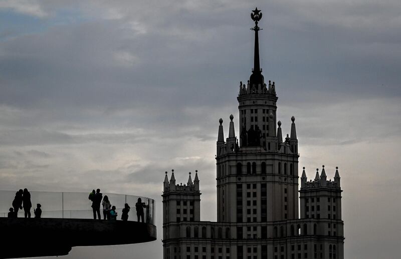 People walk on a bridge at the Zaryadye park near a Stalin-era skyscraper in central Moscow. AFP