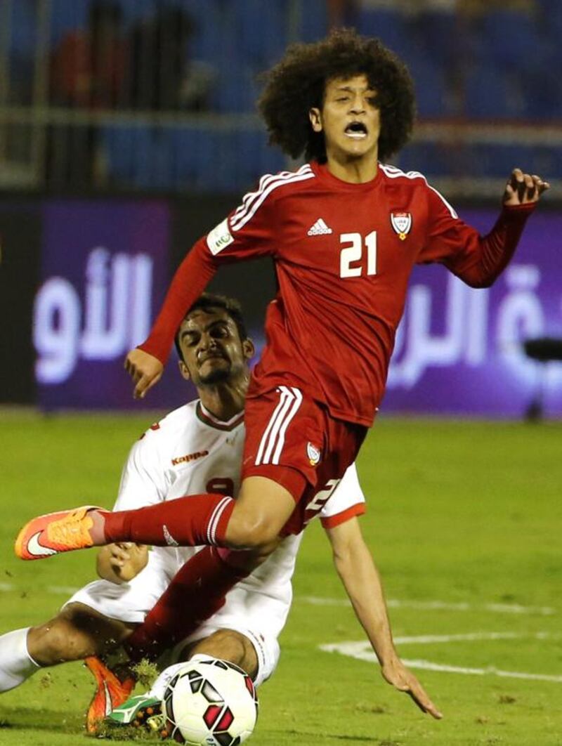 Emirati footballer Omar Abdulrahman (R) is tackled by Oman’s Eid Mohammed Al Farsi. AFP