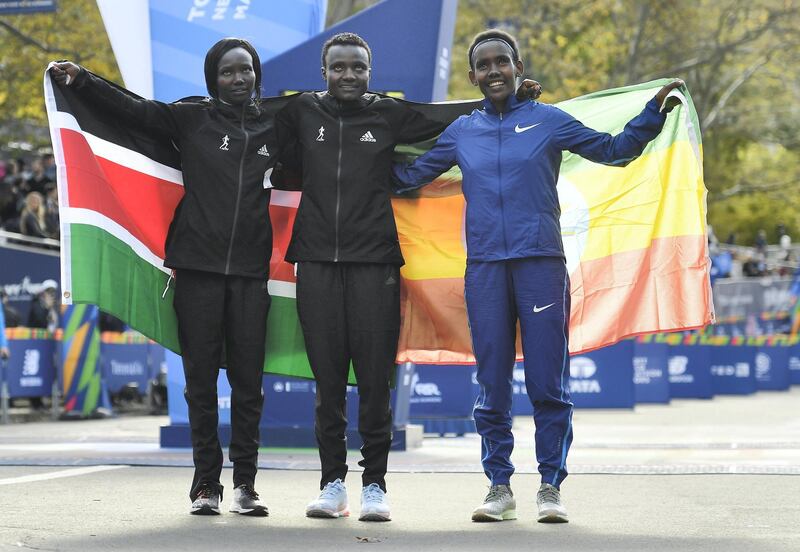 NEW YORK, NEW YORK - NOVEMBER 03: Mary Keitany of Kenya, Joyciline Jepkosgei of Kenya, and Ruti Aga of Kenya pose with country flags after taking the top three spots in the Women's Division of the 2019 TCS New York City Marathon on November 03, 2019 in New York City.   Sarah Stier/Getty Images/AFP