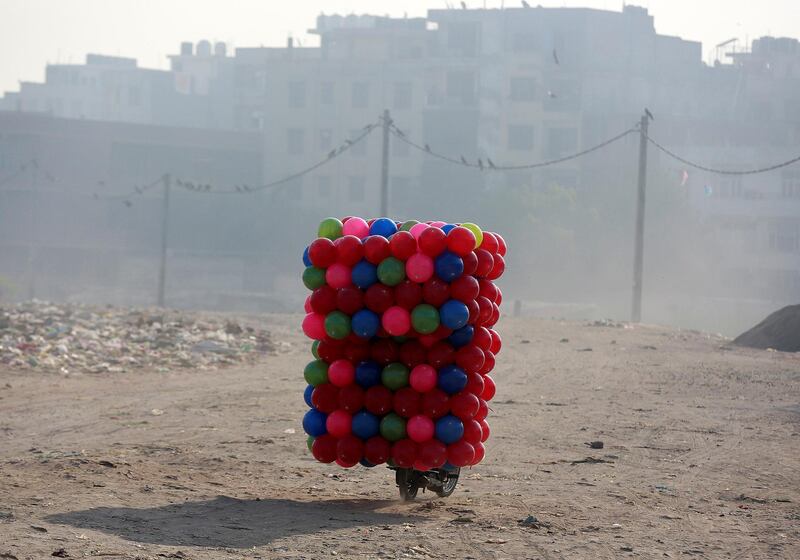 A motorcyclist rides along a road with his cargo children's coloured plastic balls in Delhi, India. Cathal McNaughton / Reuters