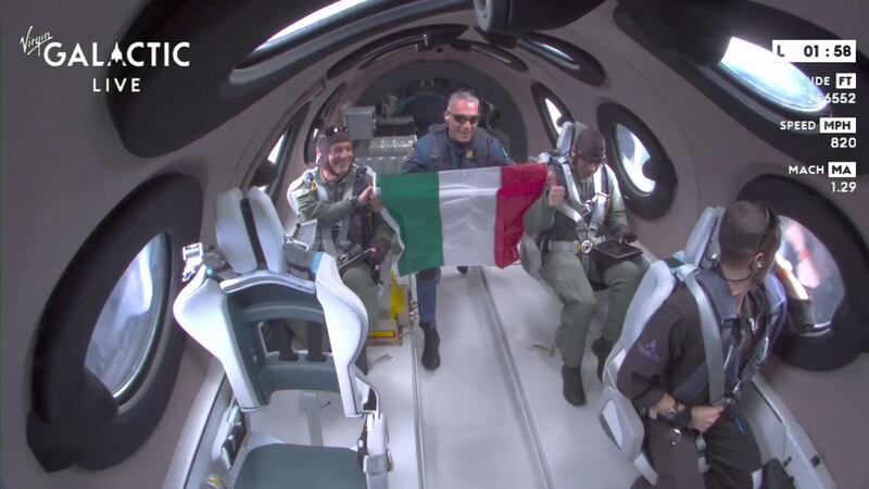 Italian Air Force member Coll Walter Villadei holds up the Italian flag while in microgravity.
