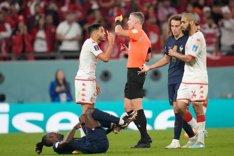 Tunisia's Wajdi Kechrida, left, gets a yellow card from referee Matthew Conger. AP