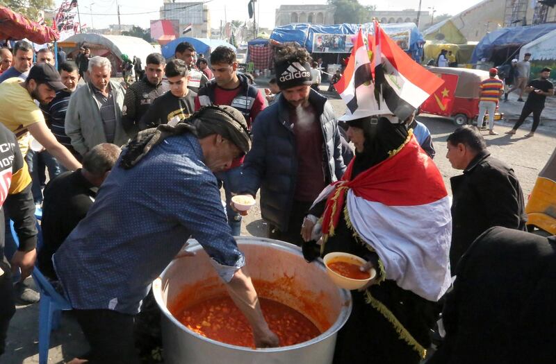 A man serves food to Iraqi protesters gathering at Baghdad's Tahrir Square. AFP