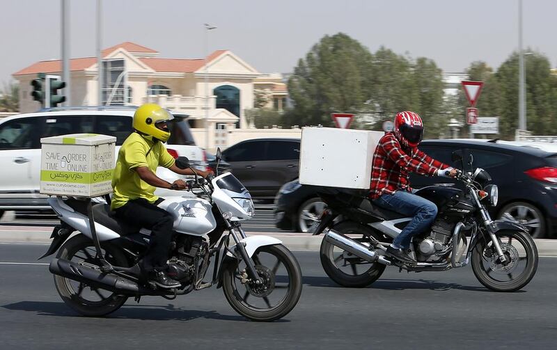 Delivery motorcyclists in Dubai, who will soon be able to pull up at designated roadside areas. Pawan Singh / The National