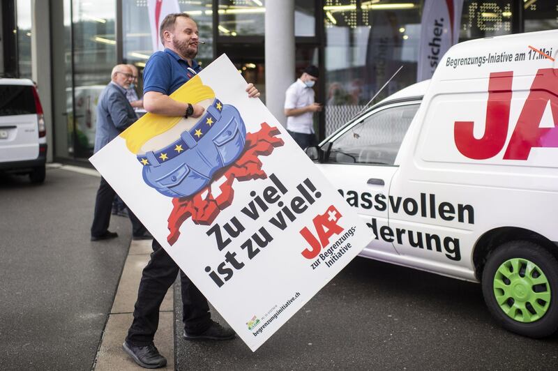 epa08699448 A man carries a poster of the Swiss People's Party (SVP) for a moderate immigration initiative reading ''Enough is enough!'' during the meeting of the delegates of the wiss People's Party (SVP), in Brugg Windisch, Switzerland, 22 August 2020. (issued 26 September 2020). The initiative 'For moderate immigration (Limitation Initiative)' launched by Swiss People's Party SVP is one of five separate issues Swiss voters will decide in the nationwide ballot on 27 September 2020.  EPA/ENNIO LEANZA