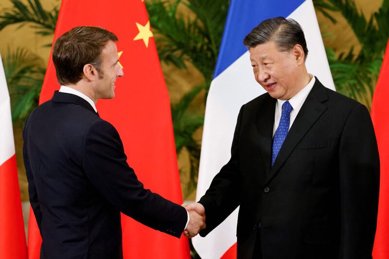 Emmanuel Macron shakes hands with Mr Xi at a meeting between the French and Chinese leaders. AFP