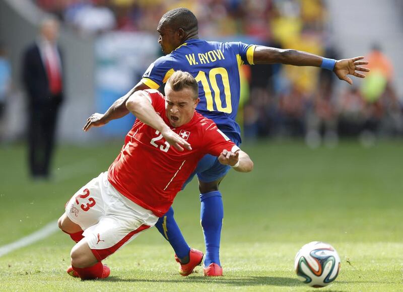 Switzerland's Xherdan Shaqiri, left, trips after being fouled by Ecuador's Walter Ayovi during their 2014 World Cup Group E match on Sunday in Brasilia, Brazil. Ueslei Marcelino / Reuters