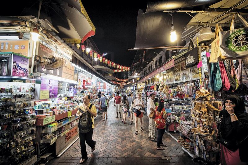 Shoppers browse street stalls in the area of Chinatown in Singapore, on Saturday, Aug. 23, 2014. Singapore is scheduled to release consumer price index (CPI) figures on Aug. 25. Photographer: Bryan van der Beek/Bloomberg