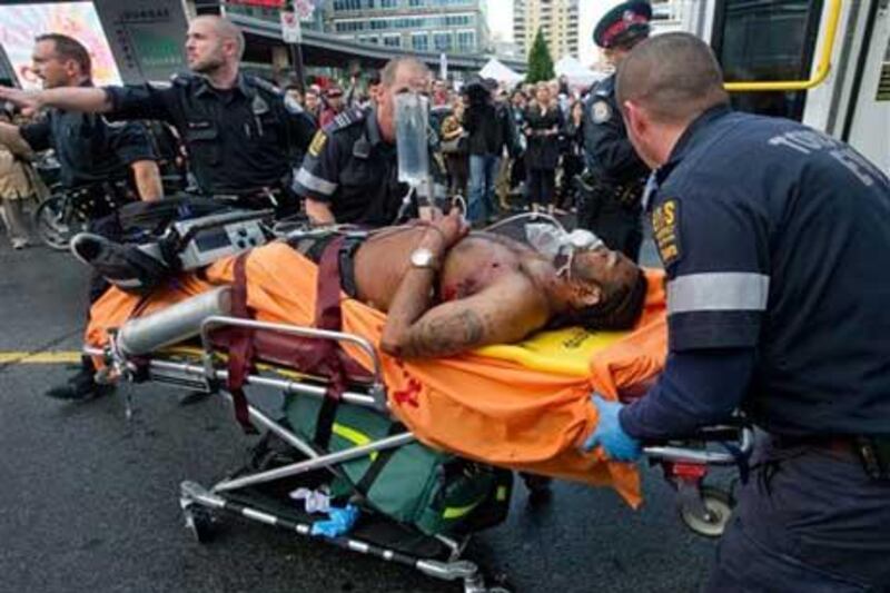 Emergency personnel wheel a shooting victim towards an ambulance for transport to hospital outside the Eaton Centre shopping mall in Toronto.