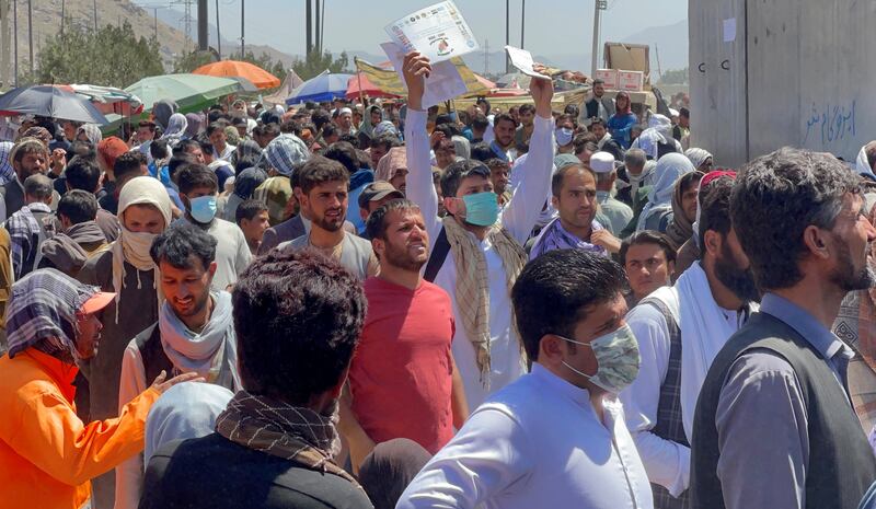 Crowds of people show their documents to US troops outside the airport in Kabul. Reuters