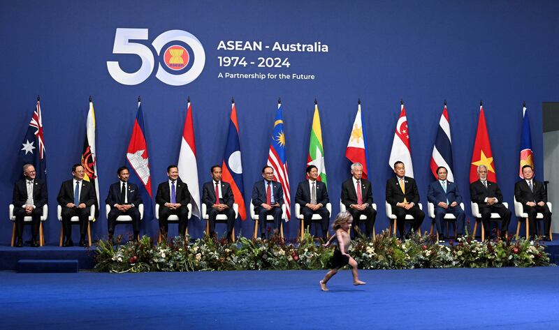 A child runs across the shot as national leaders sit for a photo at the Asean-Australia Special Summit in Melbourne. Reuters