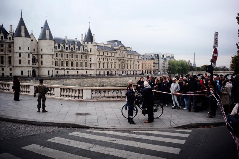 People stand behind a police tape as they near the police headquarters. AP Photo