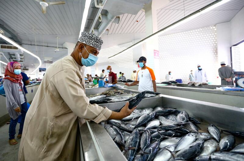 A vendor wearing a face mask against the coronavirus sells fresh fish at the Mutrah Souq in the Omani capital Muscat.  AFP