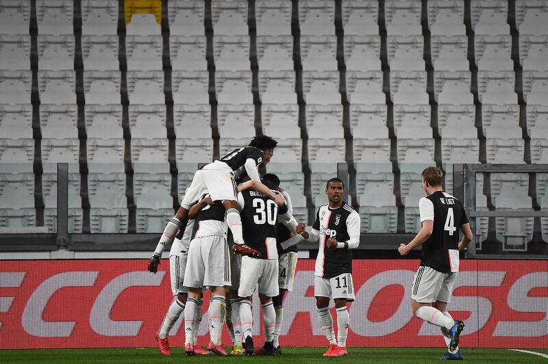 Juventus players celebrates after scoring their opener against Inter Milan in an empty stadium. AFP