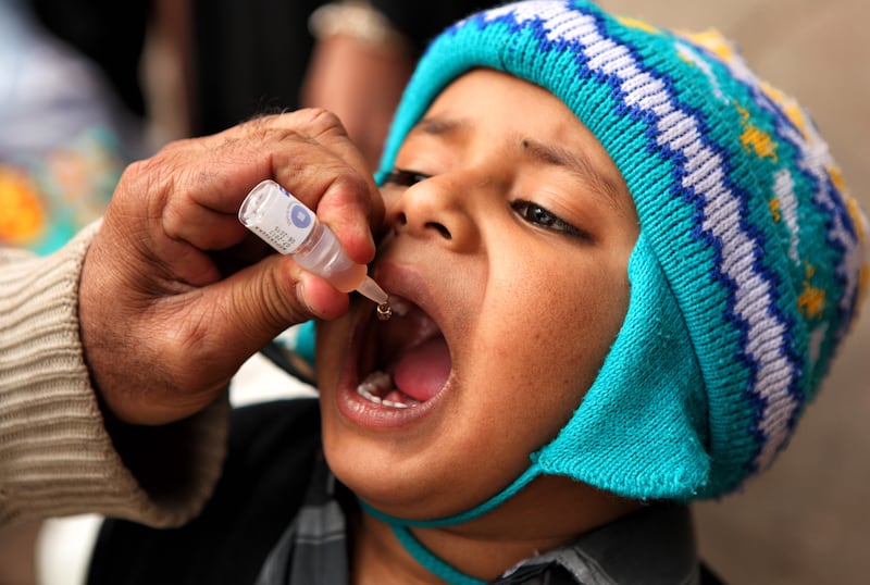 Muhammad Arshad, head of the Rotary vaccination team at Karachiâ€™s main railway station, gives polio vaccinenation to a toddler aboard a train waiting to pull out. in Karachi, Pakistan on Wednesday 08 Jan, 2014. 
Photographer: Asim Hafeez