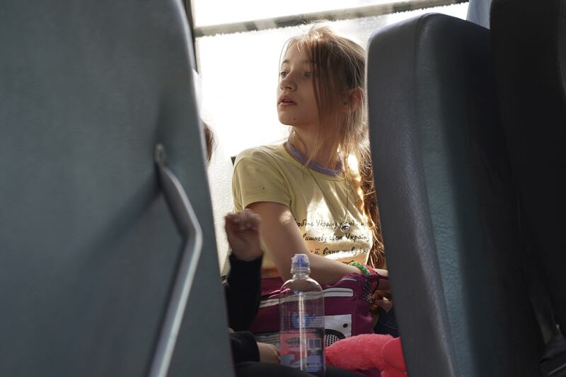 A young girl sits on a bus in Tijuana, waiting to enter the US.