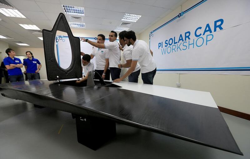 Members of the Petroleum Institute’s solar-powered car core team, from right, Razi ur Rehman, Hamad bin Shaheen, Shihab Solaiman, Khalil Al Hindawi, Yazan Al Hindawi and Asad Saeed inspect the panel of a solar vehicle at their new workshop in the Abu Dhabi institute. Ravindranath K / The National