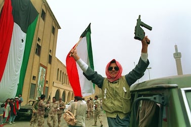 In this file photo taken on February 28, 1991, a member of the Kuwaiti resistance raises his rifle and the national flag in celebration as Kuwaiti's filled the streets after US President George Bush's announcement of a cease-fire. AFP