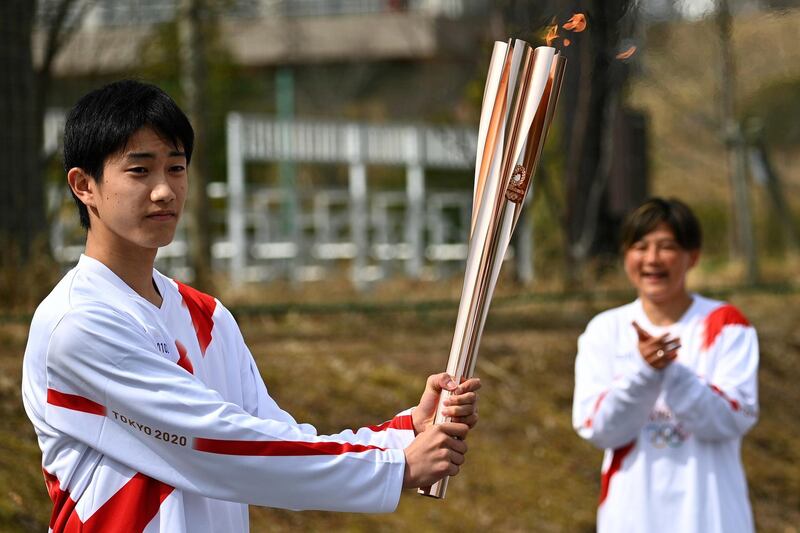 High school student Asato Owada holds the Olympic Torch. Getty