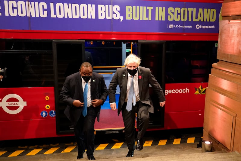 Boris Johnson arrives to attend the reception on an electric bus. AP Photo