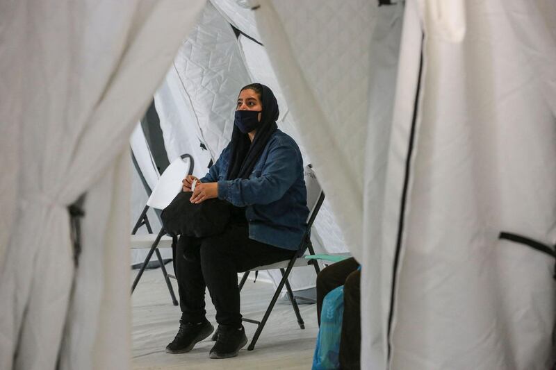 A woman waits to receive her vaccine. Greece has started to distribute Covid-19 vaccines to migrant camps after criticism authorities were taking too long to extend the programme. AFP