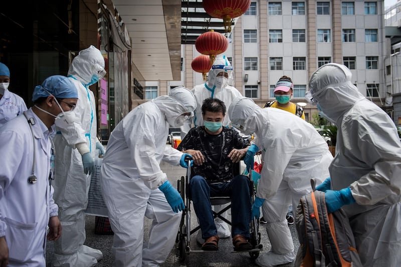 Medical workers carry a man who is the last patient recovered from the Covid19 coronavirus infection in the Wuhan, pulmonary hospital before he leaves the hospital in Wuhan, in China's central Hubei province. AFP
