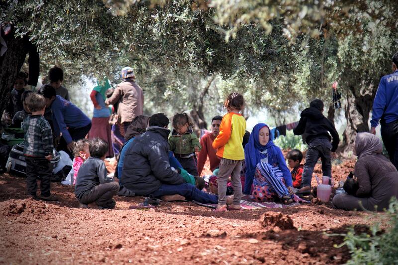 Mustafa Farhan sits with his sons and children from other displaced families on Harem mountain near Al Khair camp in Idlib, Syria, on May 4, 2019. Hashem Dardowra for The National