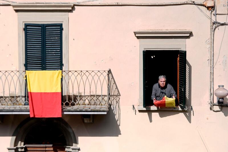 A resident holds a flag bearing the colors of the Tuscan village of Vinci, where Leonardo Da Vinci was born on April 9, 2019. AFP